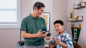 A father giving his son a Greenlight debit card.